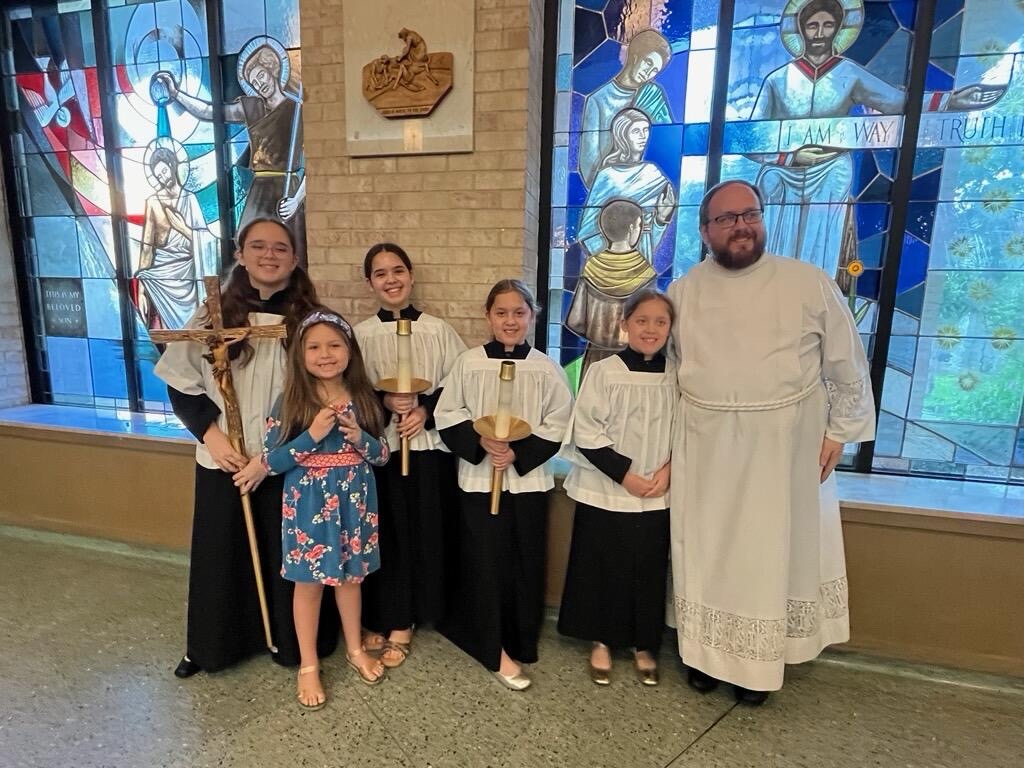 Picture of me with my daughters who are altar servers in vestments along with my youngest who "helps".